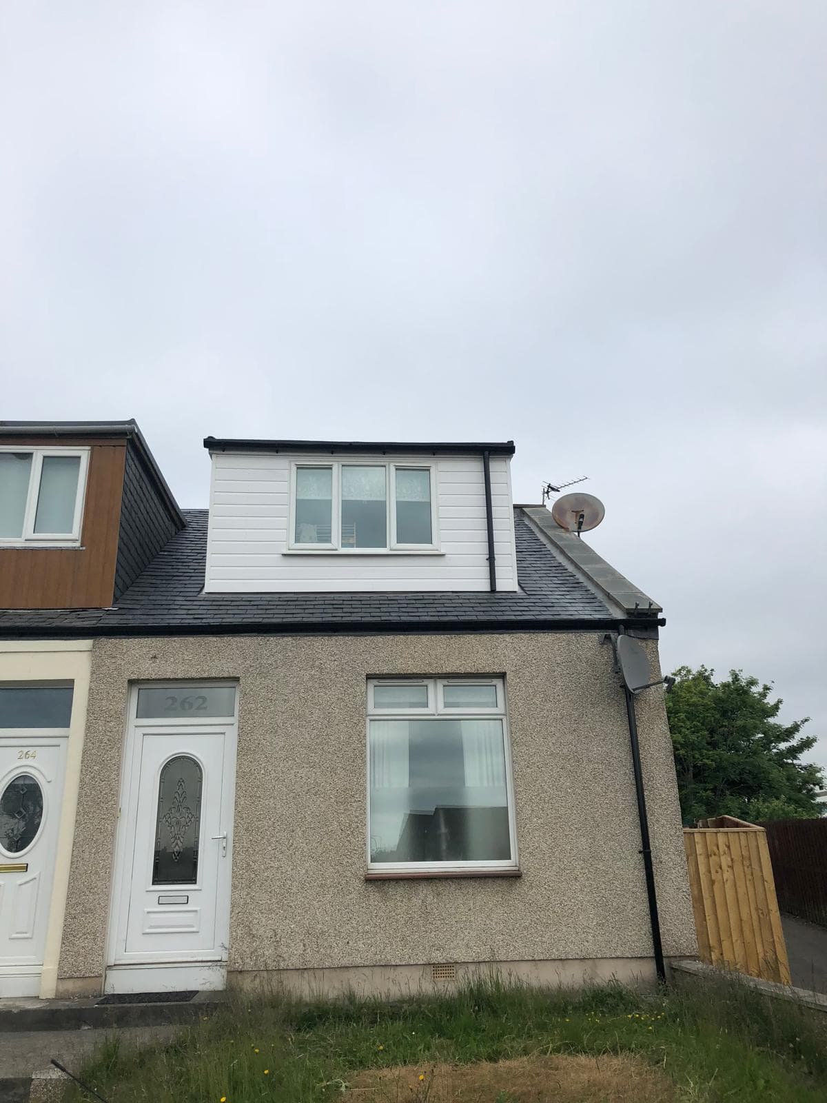 Completed house with new dormer, dark slate roof and black fascias and soffits