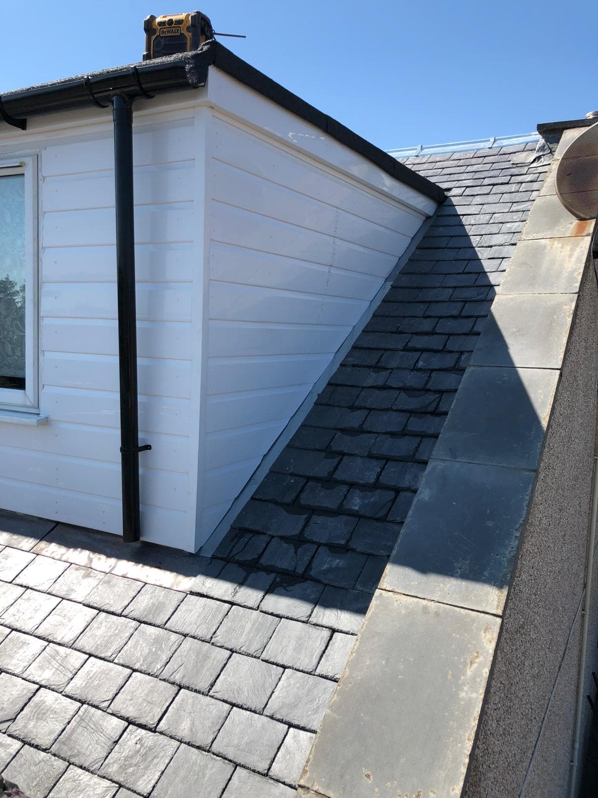 Completed slate roof with new black fascias, soffits and gutters on dormer