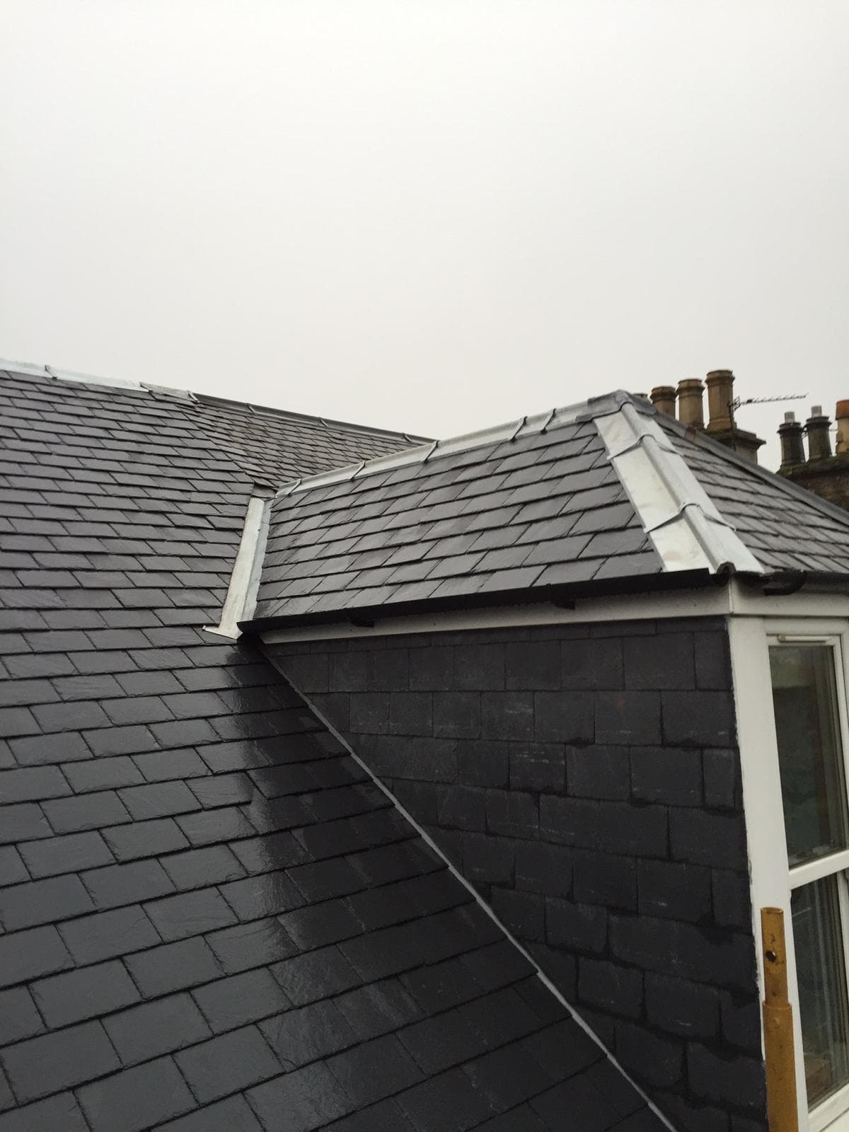 New slate roof on Scottish tenement building with white lead flashing